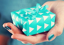 A woman's hand holding out a gift