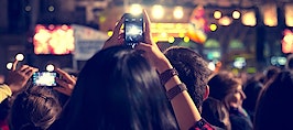 Music festival-goers taking video at a concert