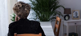 A retired woman sitting at a table