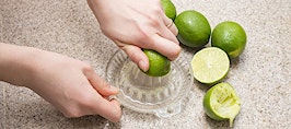 Two hands squeezing limes