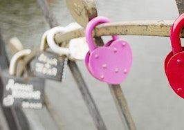 Heart-shaped locks chained to a bridge