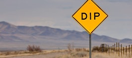 A sign on the road announcing a dip ahead