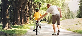 A father helping his son ride a bicycle