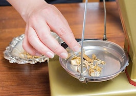 A jeweler weighing pieces to value