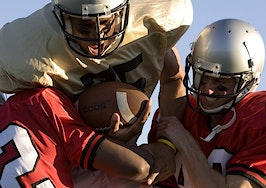 Two defense lineman tackling a quarterback