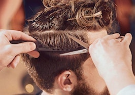 A barber trimming a man's hair