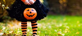 A young girl in a witch outfit with a Halloween candy pail