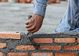 A man laying brick using mortar